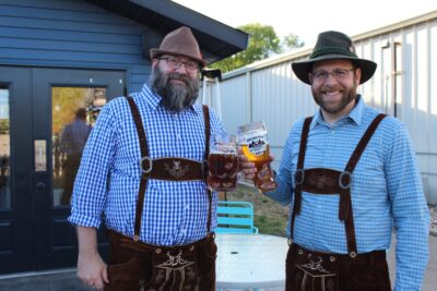 two men holding a beer celebrating Oktoberfest